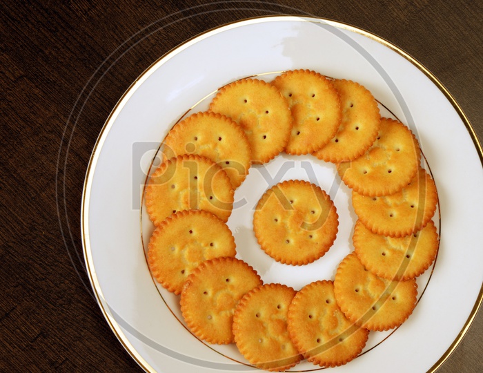 Salty cookies or biscuits  in a plate on bkack baground