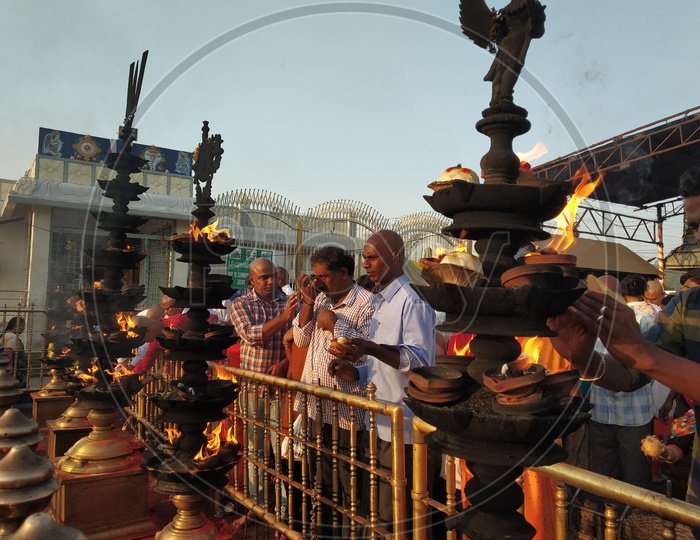 Pilgrims offering prayers in front of the oil lamps