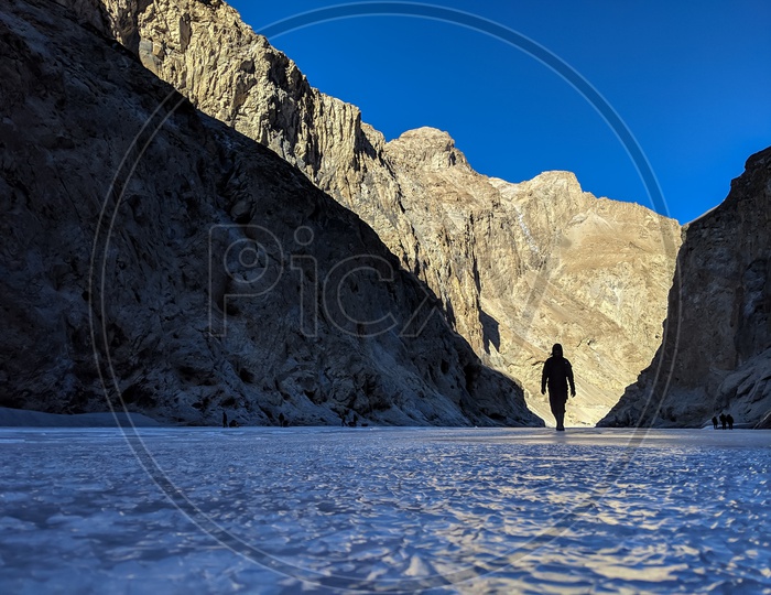 Silhouette of an Adventurer Or Man Walking On The Frozen Ice of River Zanskar  Valley