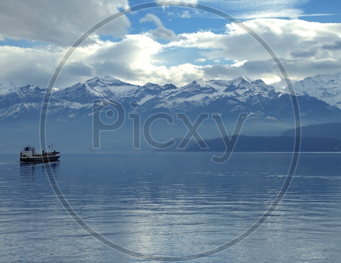 Beautiful swiss alps with boat sailing in the foreground