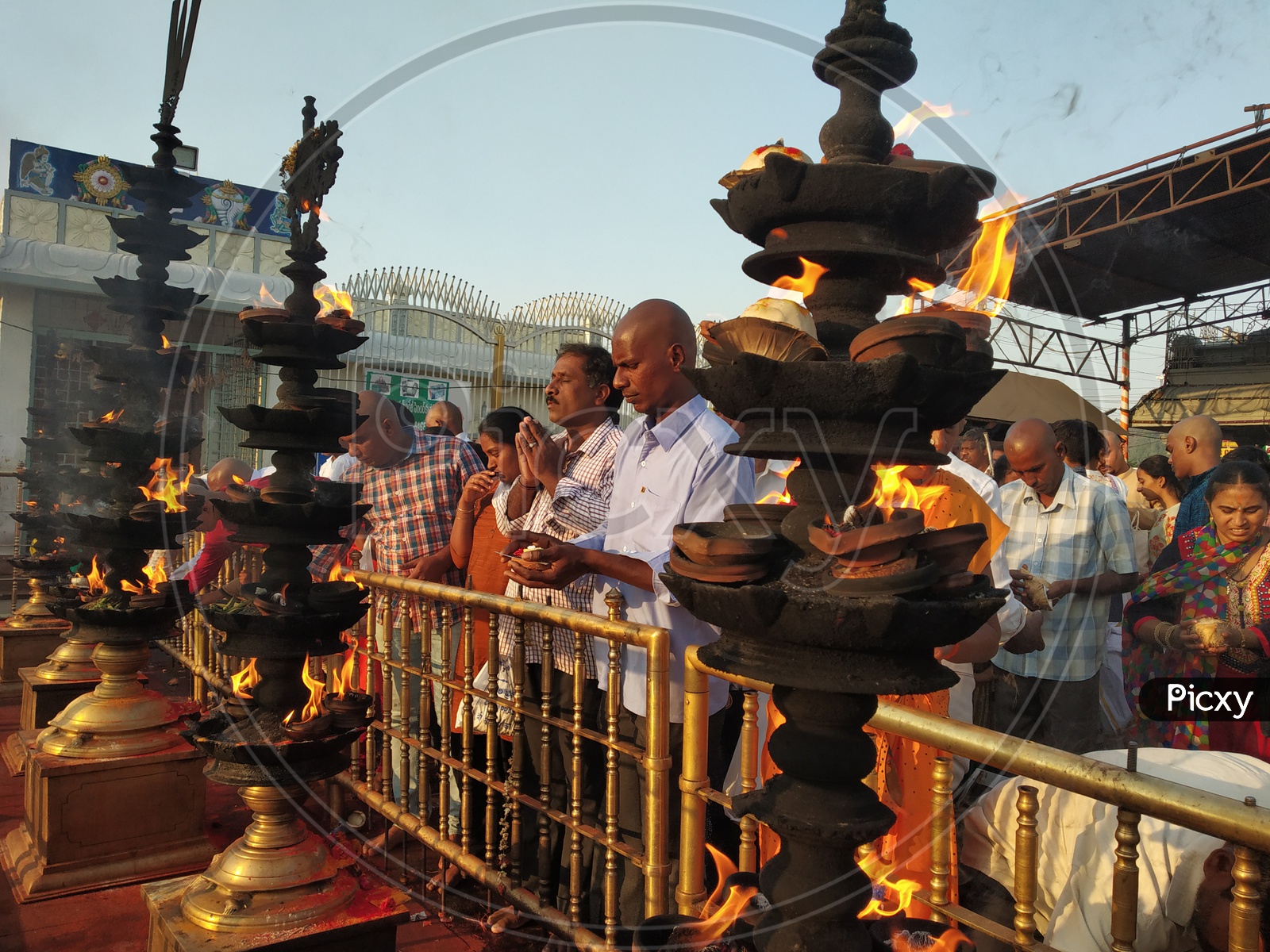 Pilgrims offering prayers by the oil lamps