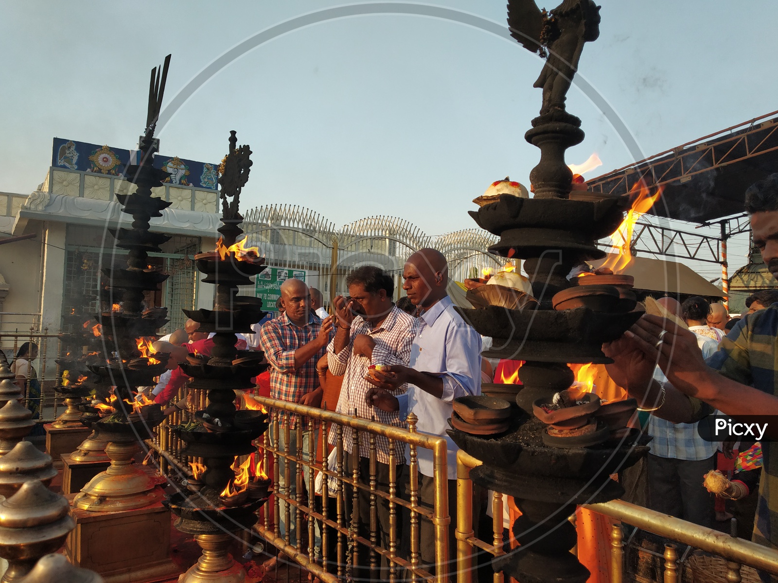 Pilgrims offering prayers in front of the oil lamps