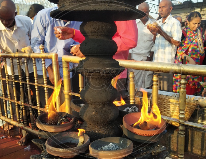 Pilgrims offering prayers by the oil lamps
