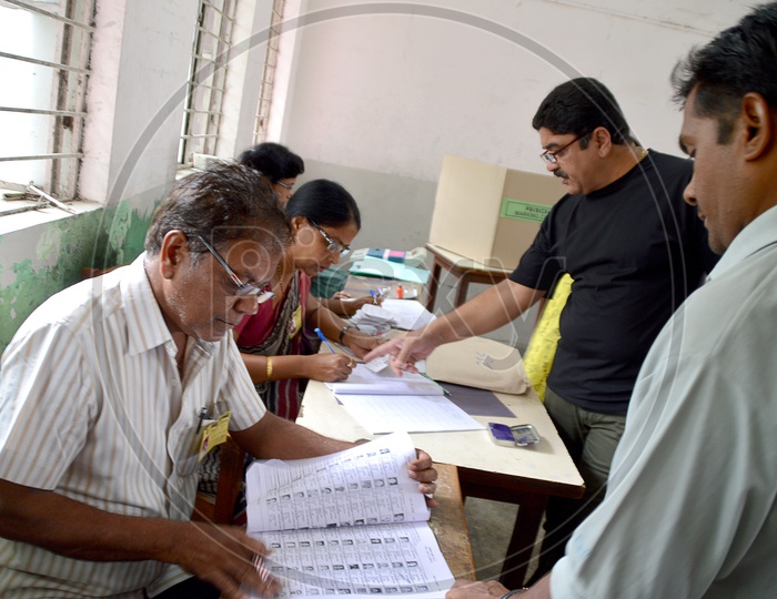 people and polling officers at polling center during election.