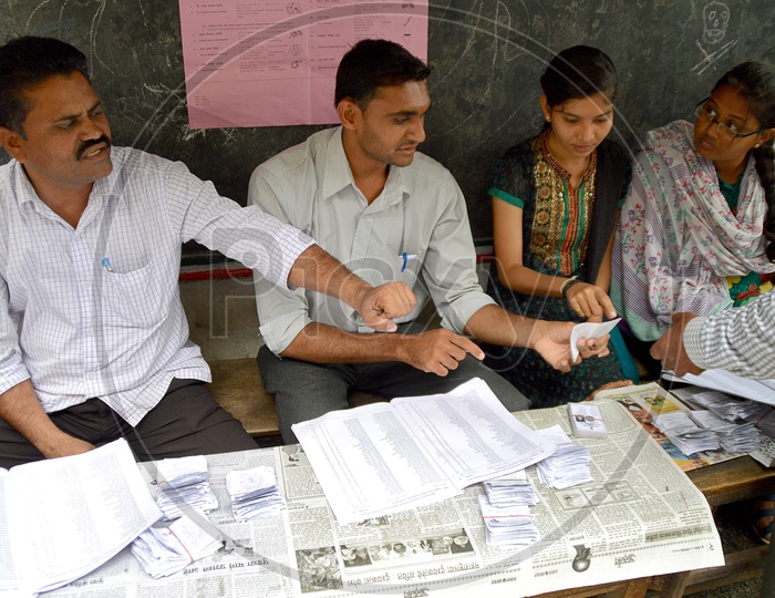 people and polling officers at polling center during election.