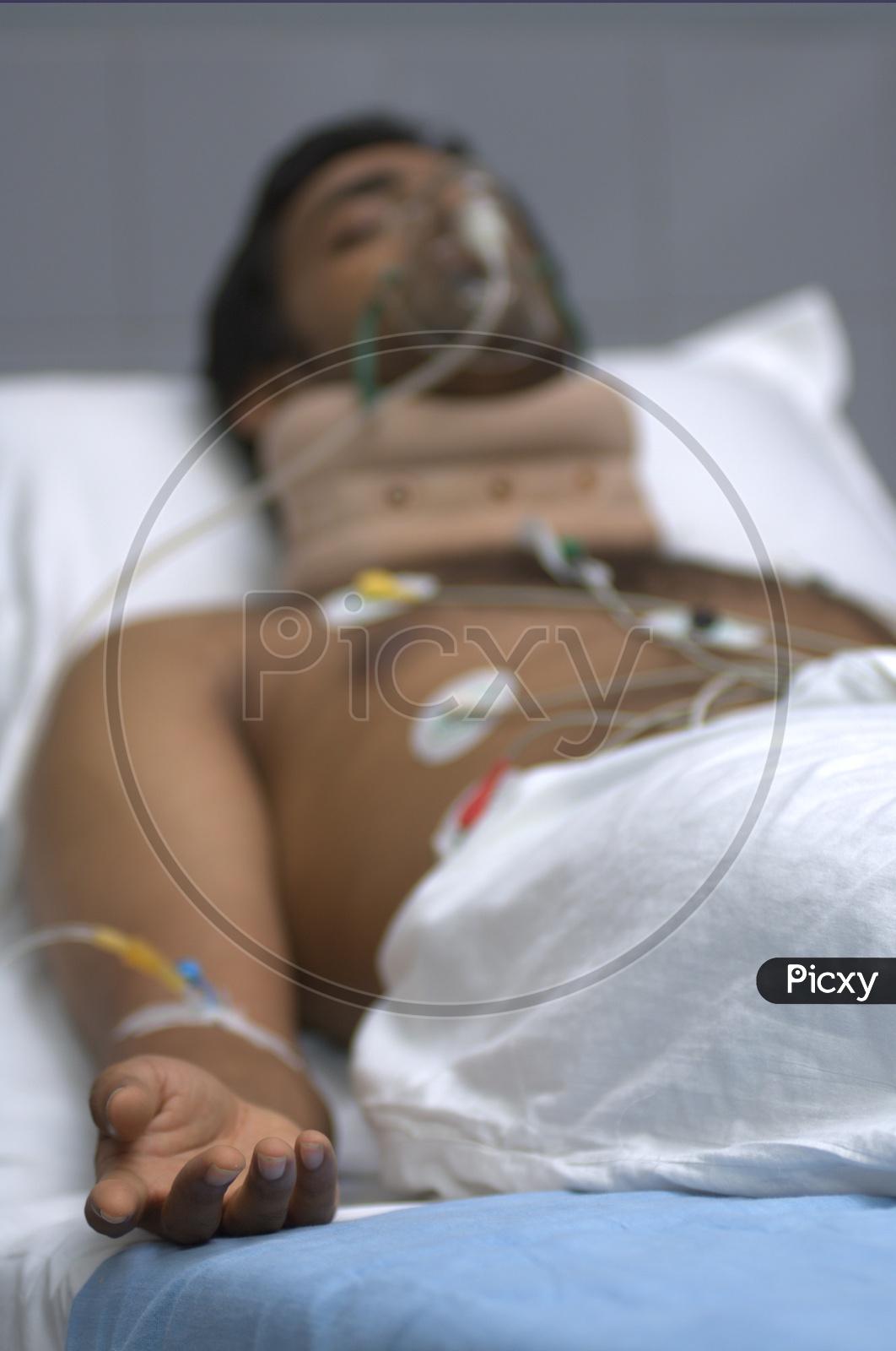 Patient with electrodes on his chest on a hospital bed