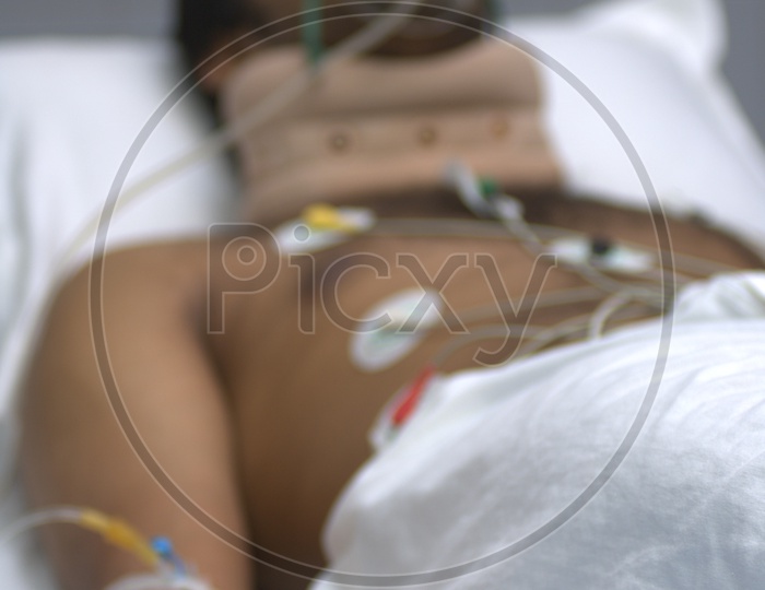 Patient with electrodes on his chest on a hospital bed