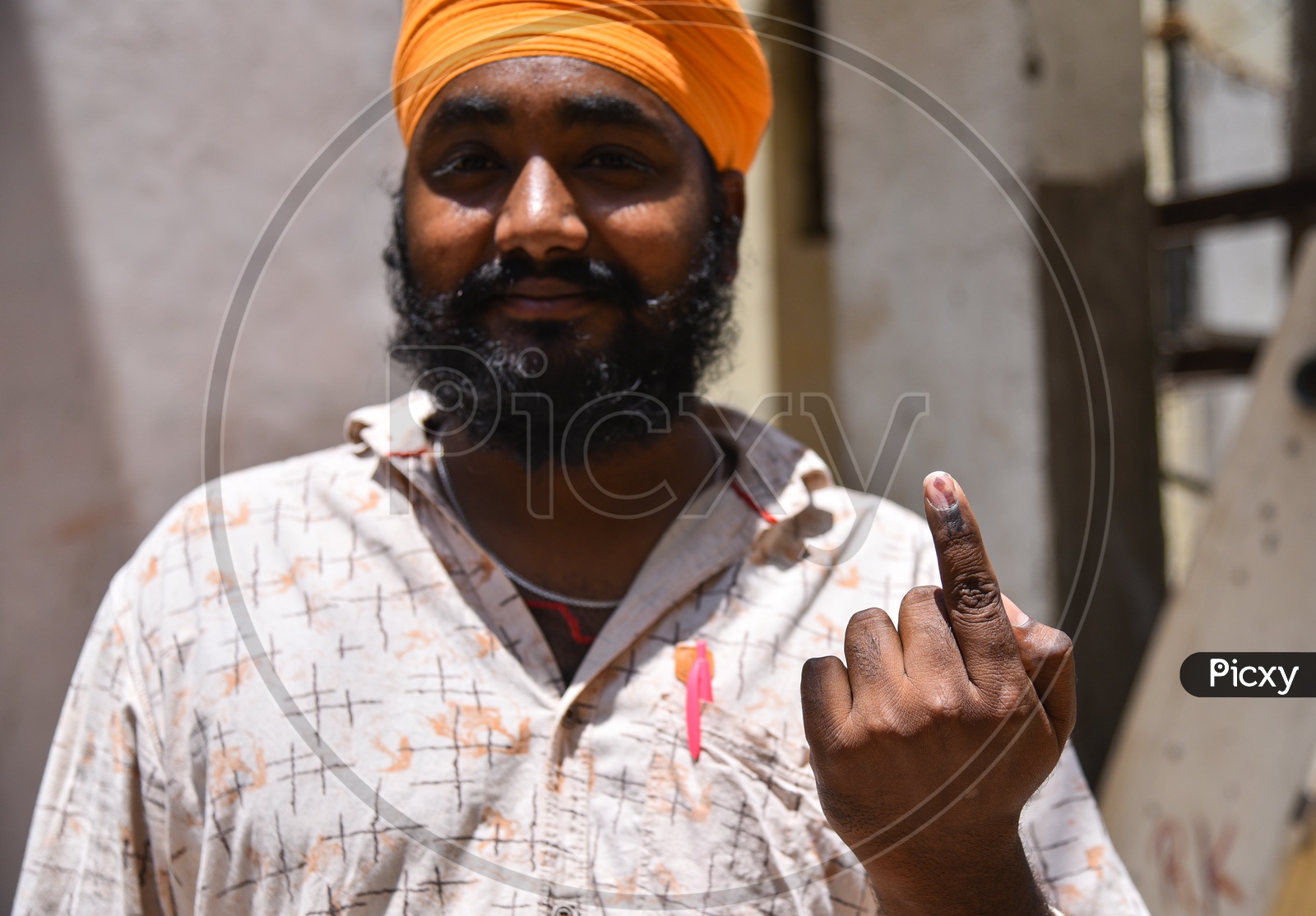 A Sikh Voter showing his Inked finger after voting.
