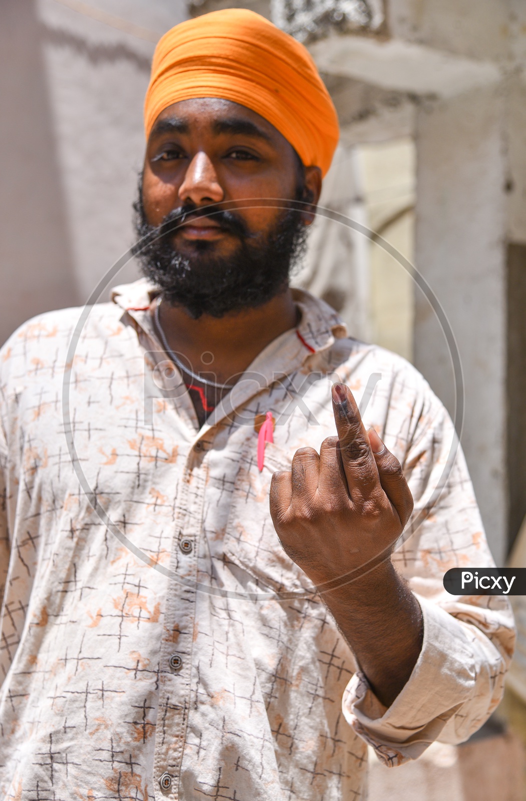 A Sikh Voter showing his Inked finger after voting.