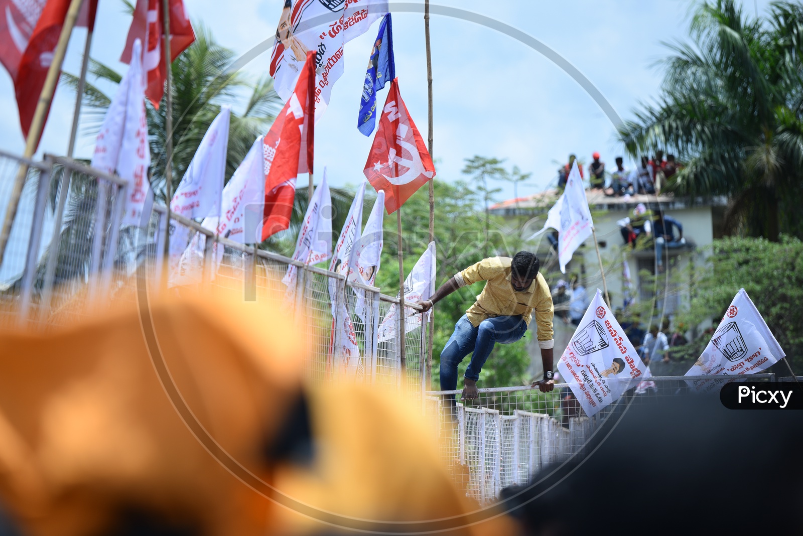 Jana sena party supporter jumping over the barricade at an election campaign in Amalapuram