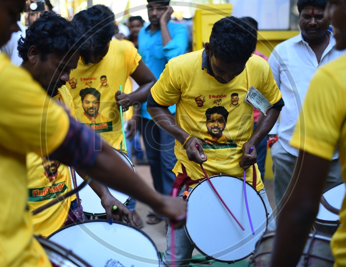 TDP party supporters wearing party t-shirts and playing drums at an election campaign rally