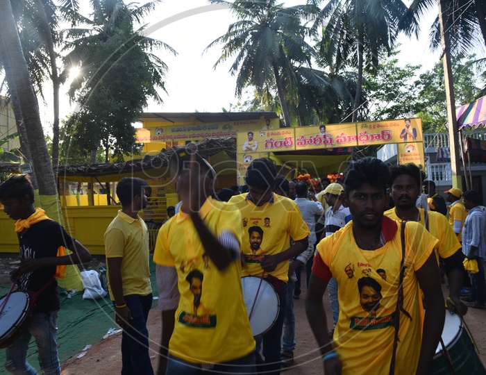TDP party supporters wearing party t-shirts and playing drums at an election campaign rally in Amalapuram