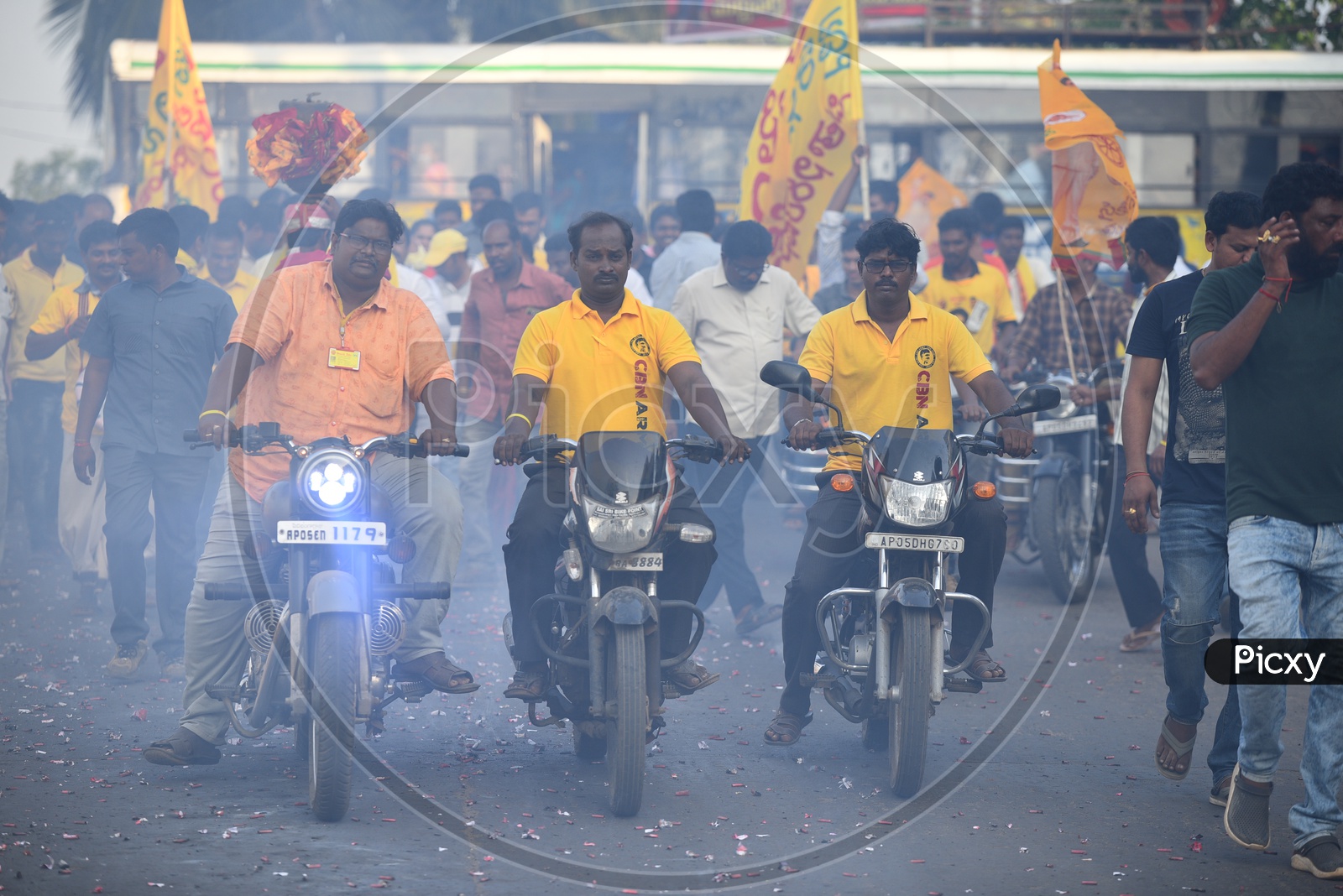 TDP party supporters wearing party t-shirts and riding bikes at an election campaign rally in Amalapuram