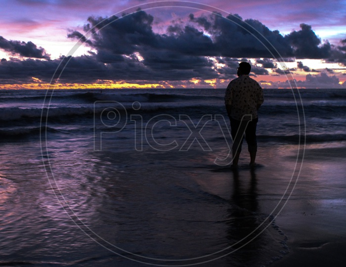 Silhouette Of a Man in Beach With Sunset  Blue Hour Sky In Background