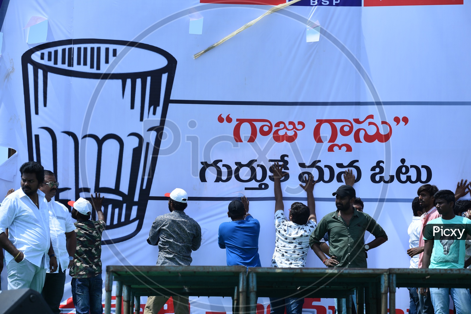 Jana Sena party supporters setting up the banner at an election campaign in Amalapuram