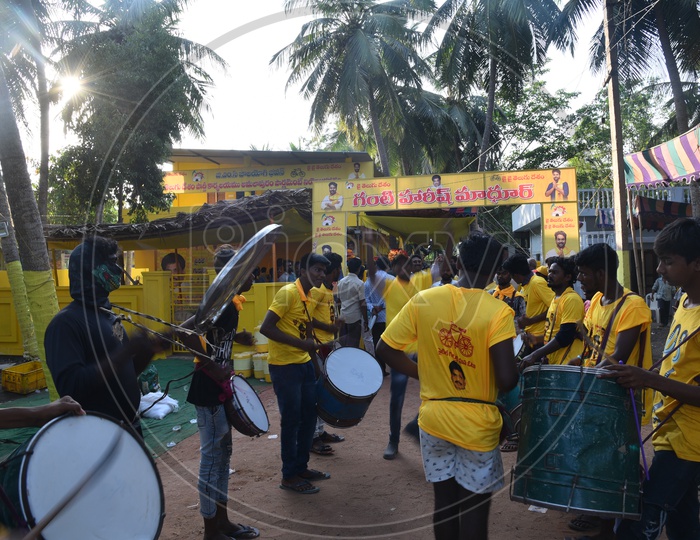 TDP party supporters wearing party t-shirts and playing drums at an election campaign rally in Amalapuram