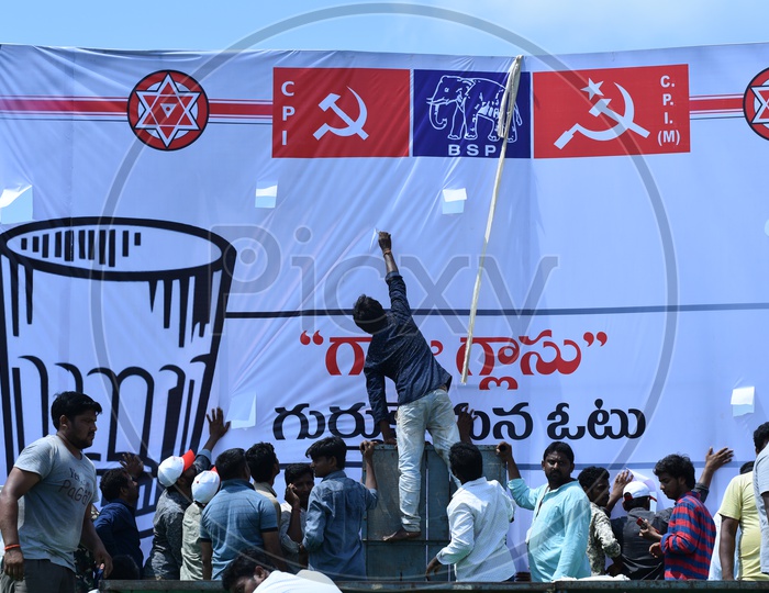 Jana Sena party supporters setting up the banner at an election campaign in Amalapuram