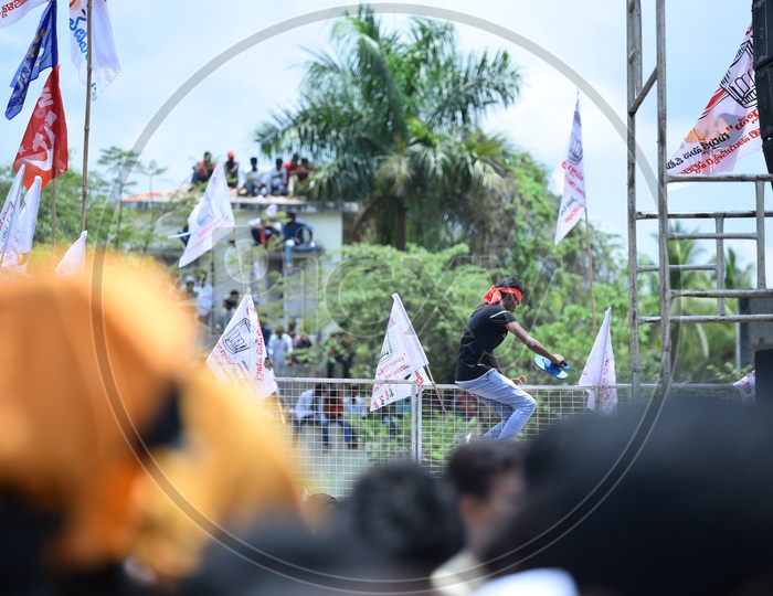 Jana sena party supporter jumping over the barricade at an election campaign