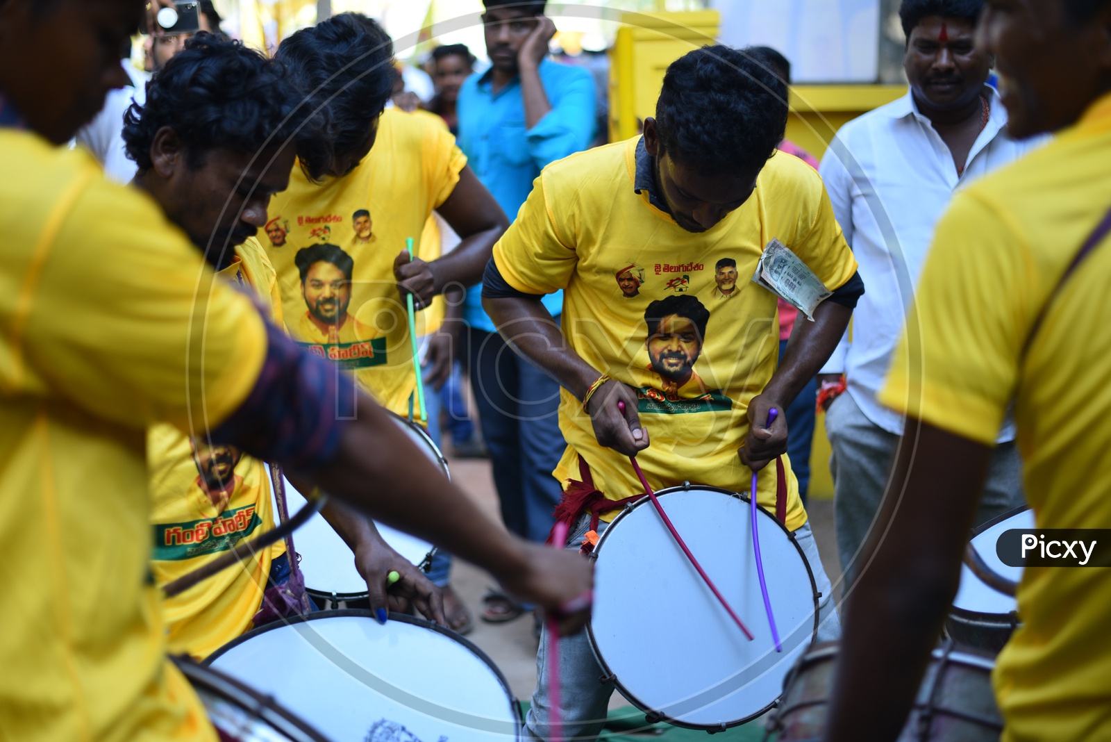 TDP party supporters wearing party t-shirts and playing drums at an election campaign rally