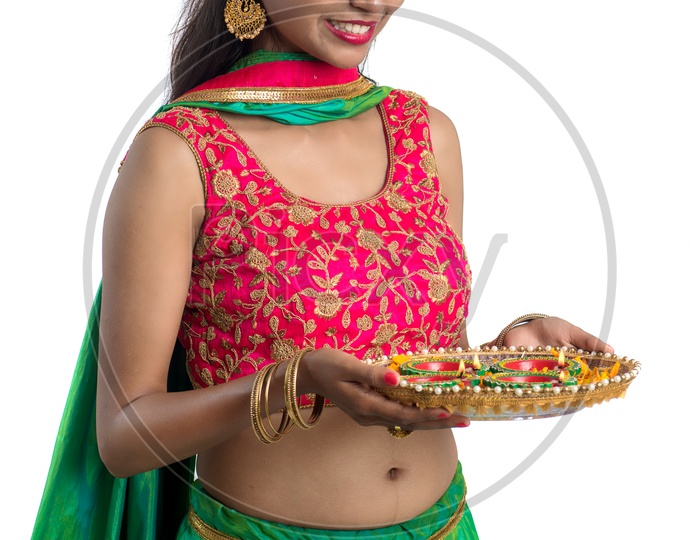 Portrait Of a Young Traditional Indian Girl Holding Dia  Plate in Hand  over an Isolated White Background