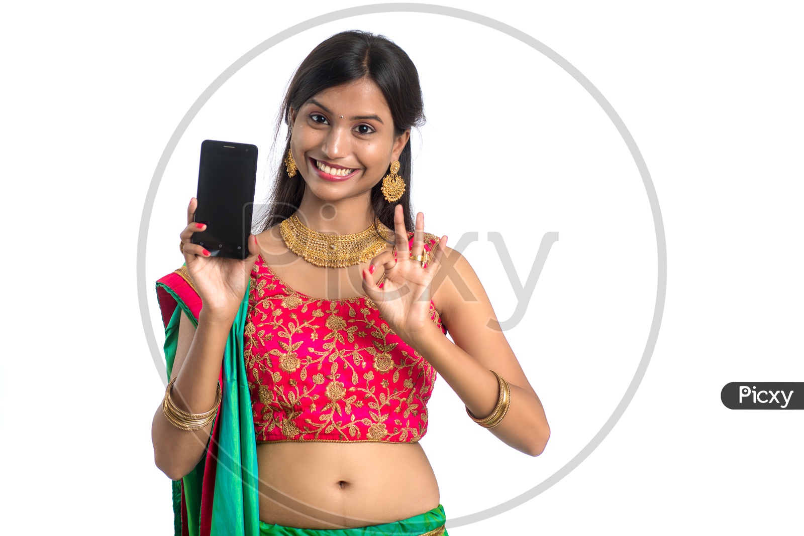 Portrait of a Young Traditional Indian  Woman  Showing Mobile Screen With an Expression and  a Gesture  over a White Isolated Background