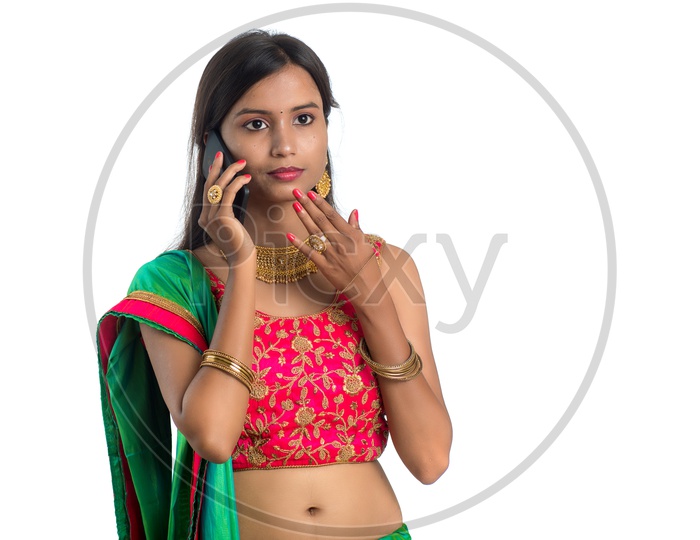 Portrait of a Happy Young  Traditional Indian Woman  Speaking In Smart Phone  Over a White  Background