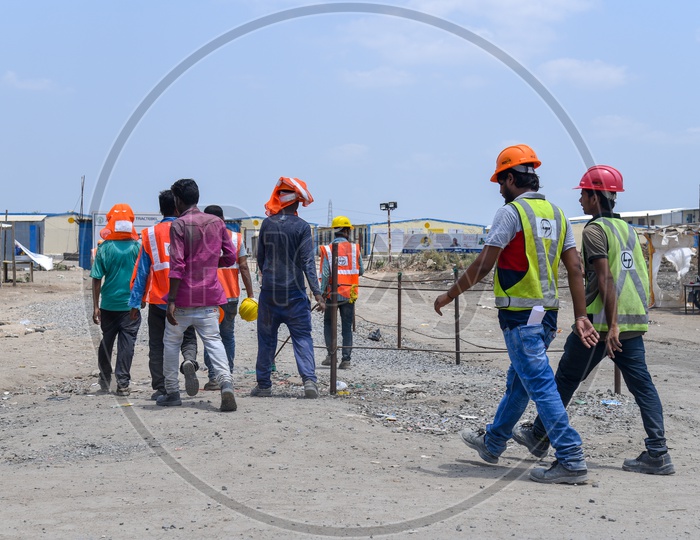 Construction Workers Wearing Safety Helmets and Reflective Safety Vests At Construction Sites