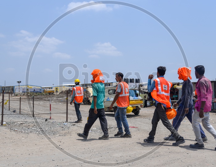 Construction Company Workers Wearing Safety Helmet and Reflective Safety Vest At Construction Company Working Site