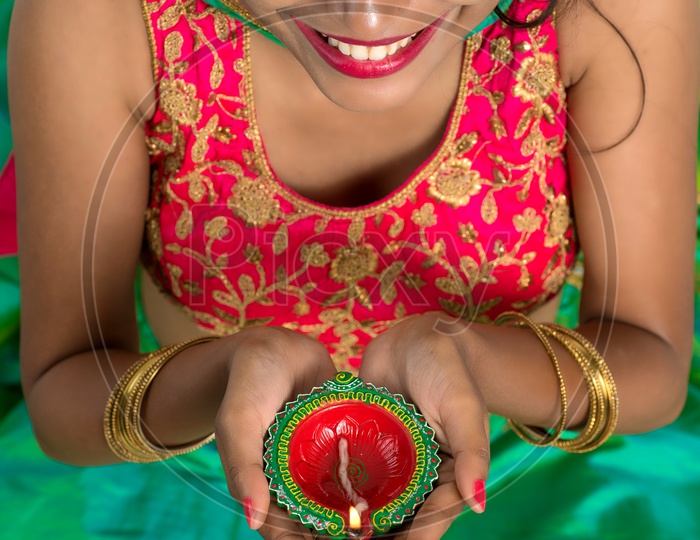 Portrait of a Young Traditional Indian Woman  Holding Festival Dia  in Hand