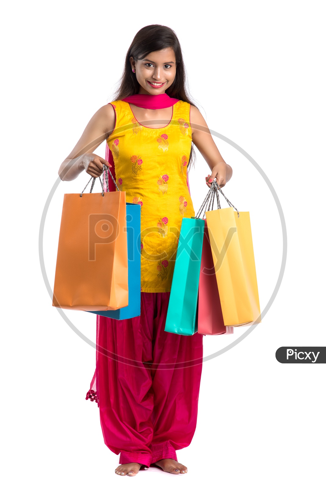 Beautiful Indian Girl holding Shopping Bags In Hand  and Posing Over a White Background