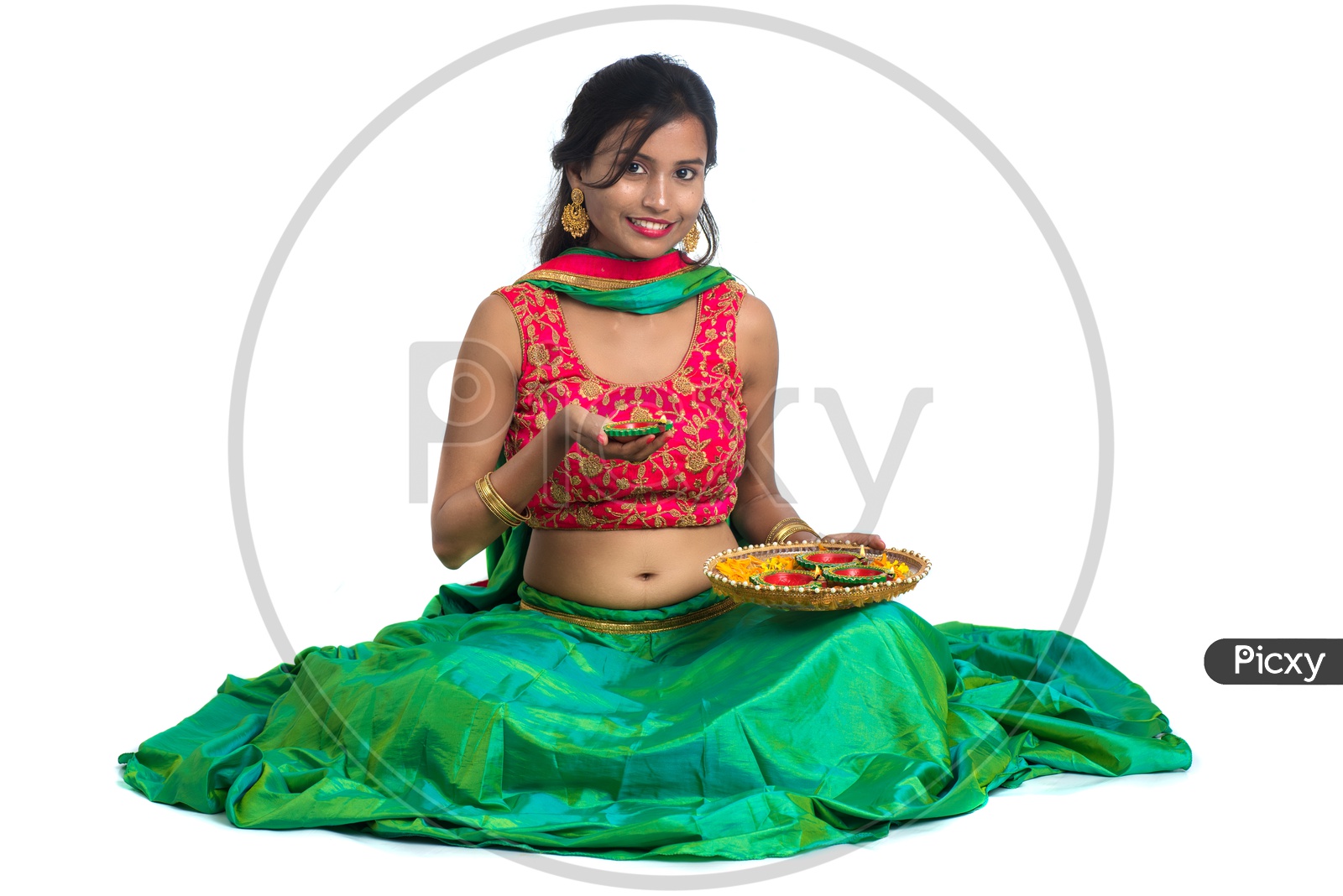 Portrait Of a Young Indian Traditional Woman Holding  Festival Dia  Plates  In Hand  Over a White Background