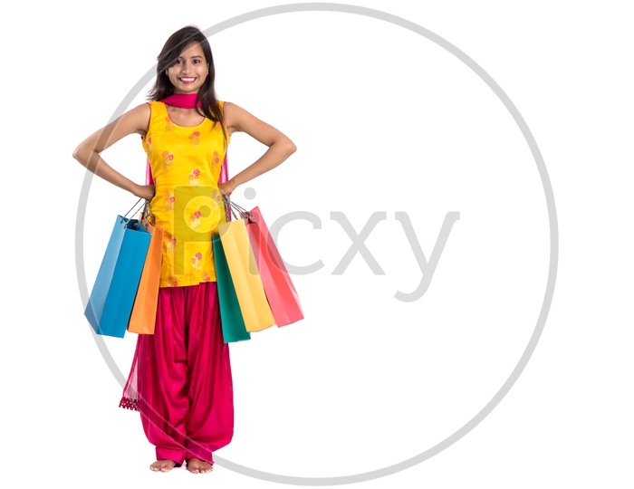 Beautiful Indian Girl holding Shopping Bags In Hand  and Posing Over a White Background