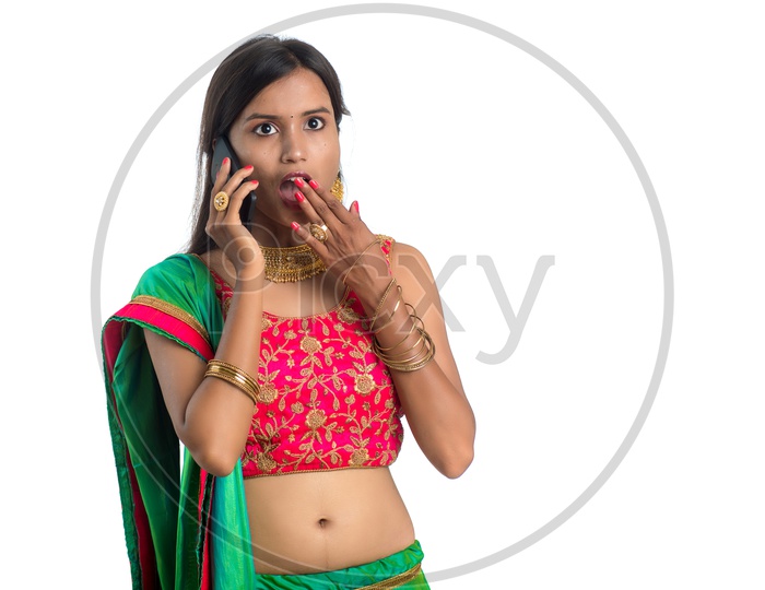 Portrait Of a Young Traditional Indian Woman Speaking In Smart phone With an Expression  Over A White Background
