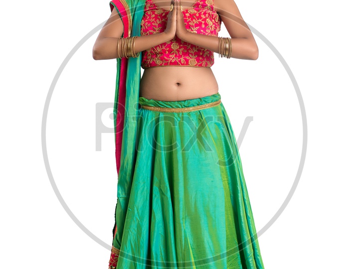 Portrait Of a Happy Young  Indian  Traditional   Woman   Doing Namasthe  Gesture over a White Background