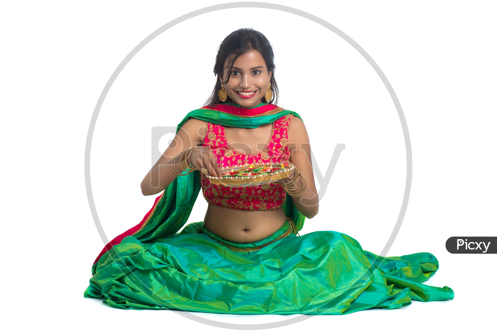 Portrait Of a Young Indian Traditional Woman Holding Dia Plates In Hand  Over a White Background