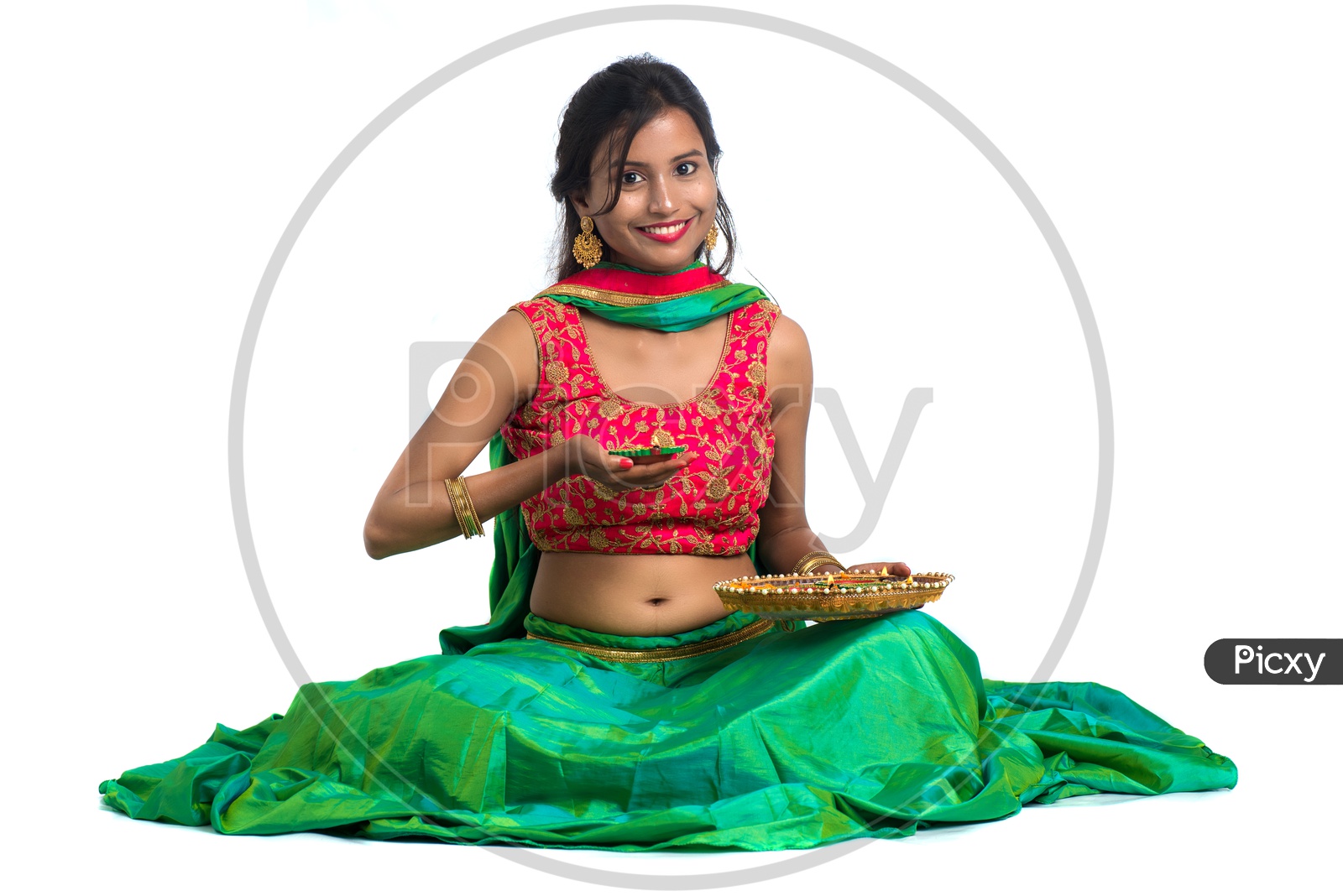 Portrait Of a Young Indian Traditional Woman Holding Dia Plates In Hand  Over a White Background