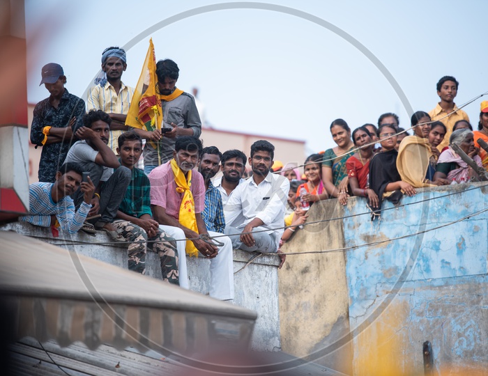TDP Party Supporters Sitting On a Building Pit Wall and  Listening Curiously to Speech