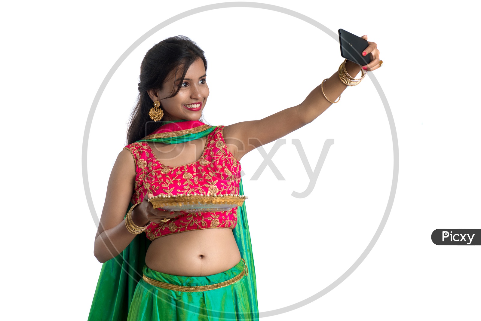 Portrait of a Young Indian Traditional Girl  Holding  Dia Plate And  Dia In Hand and Taking Selfie   Over an Isolated White Background