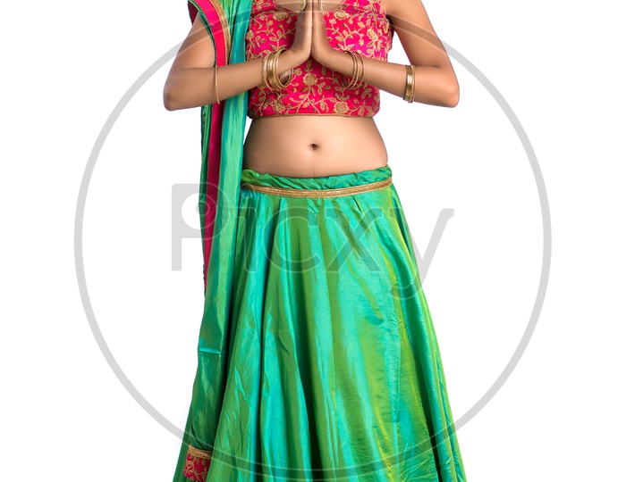 Portrait Of a Happy Young  Indian  Traditional   Woman   Doing Namasthe  Gesture over a White Background