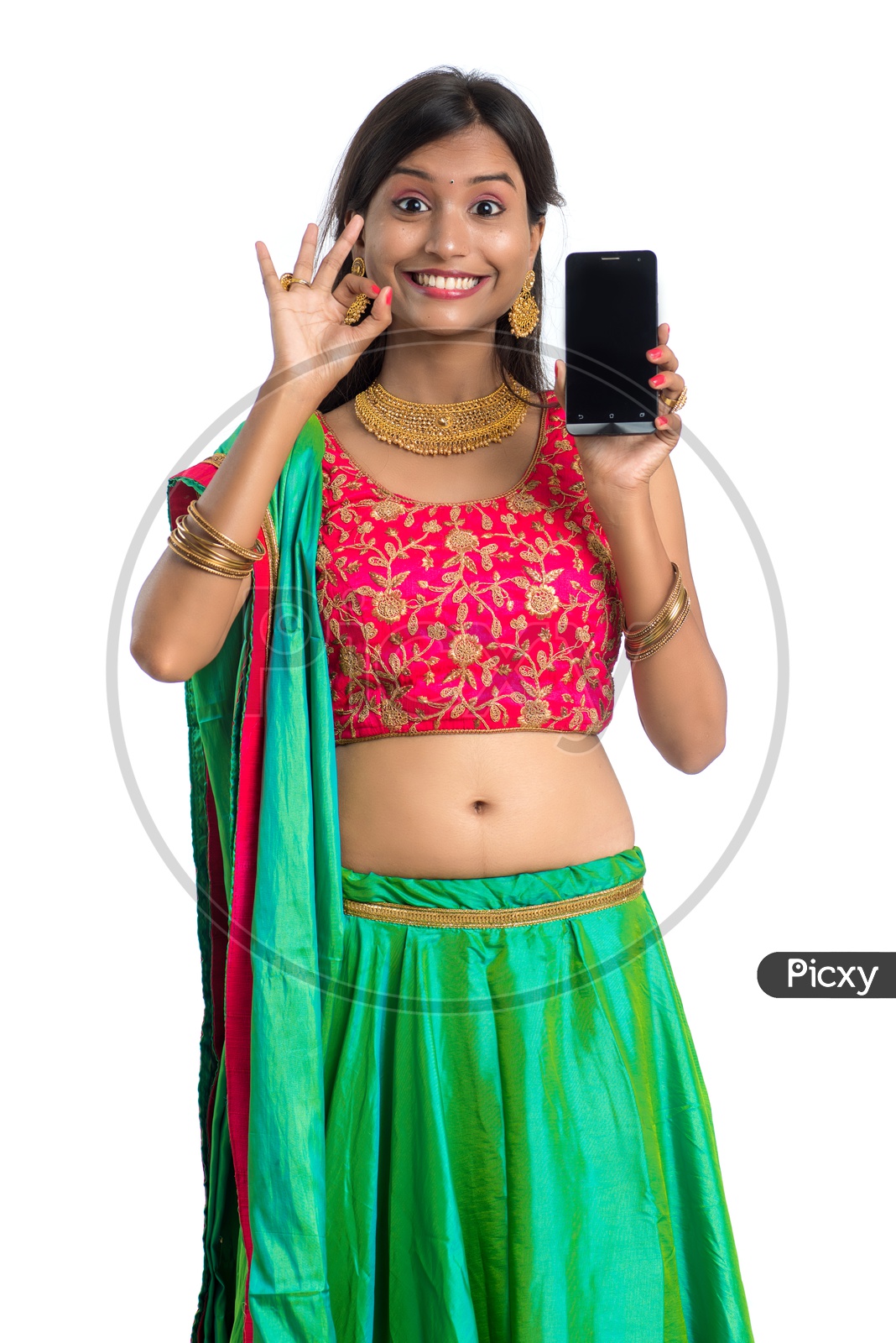 Portrait Of a Young  Traditional Indian  Woman  Showing Smart Phone Screen and  With an Expression an d a Gesture Over a White Background