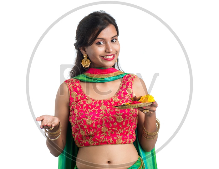 Portrait Of a Young India Traditional Woman  Holding Pooja Plate Or Dia  in Hand  Over a White  Background