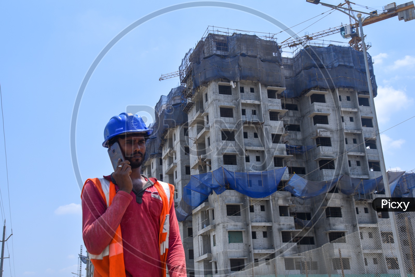 A Construction Company Worker Speaking  in Smart Phone At a Construction Site