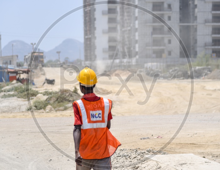 Construction Site Workers Wearing Safety Helmets  and  Reflective Safety Vests At Construction Sites