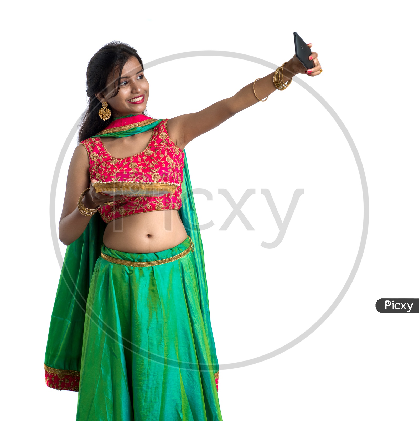 Portrait of a Young Indian Traditional Girl  Holding  Dia Plate And  Dia In Hand  and Taking  Selfie Over an Isolated White Background