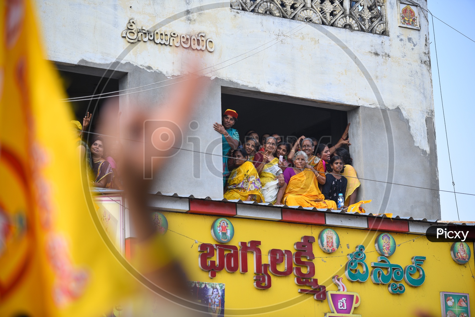 Woman  TDP Party Supporters Sitting On a Building Pit Wall and  Listening Curiously to Speech