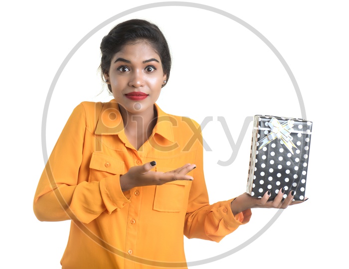 A Happy Young  Indian Girl Holding Gift Boxes in Hand And With a Smile Face on an Isolated White Background