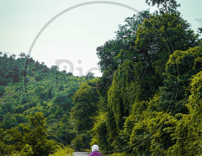 A Man Riding a Bike On The Rural Village Roads