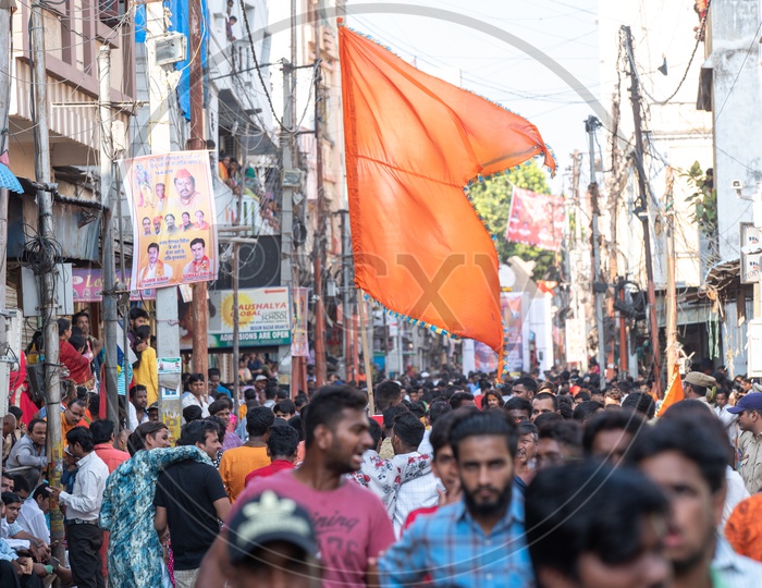 A man holding a saffron flag in a crowd at Shri Rama Shobha yatra in Hyderabad
