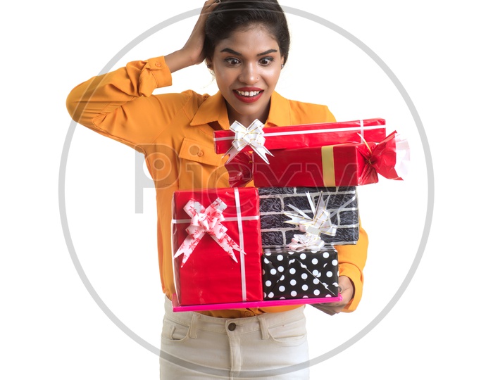 An Excited young Beautiful Indian Girl Holding Gift Box in Hand on an Isolated White Background