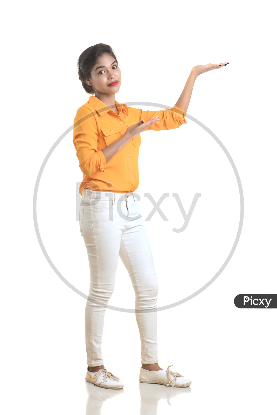 Indian woman wearing orange shirt and white pant